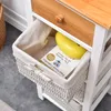 A close-up view of a drawer in a white and brown dresser, revealing a woven basket with a book and a yellow object inside. Podgląd zdjęcia produktu