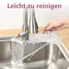 A hand is rinsing a clear acrylic shelf under a kitchen faucet. Produktbild-Vorschau