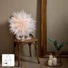 A large white paper star decoration with gold accents is placed on a wooden chair next to a mirror and some candles. Podgląd zdjęcia produktu