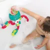 A child playing with a bath toy in a bathtub filled with bubbles. Produktbild-Vorschau