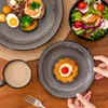 A table setting with plates of food, a salad bowl, and a cup of coffee. Produktbild-Vorschau