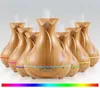 A group of wooden-style aroma diffusers with LED lights emitting mist. Produktbild-Vorschau