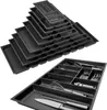 A stack of drawer organizers and a single drawer organizer filled with kitchen utensils. Produktbild-Vorschau