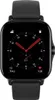 A close-up of a black smartwatch with a black strap, displaying the time and other metrics on its screen. Voir les images du produit