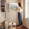Frau betrachtet die SoBuy Wandvitrine FSB114-E-W mit geöffneter Tür und Sammlermodellen Voir les images du produit