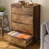 A rustic wooden dresser with an open drawer revealing colorful items, next to a small stool with a potted plant. Podgląd zdjęcia produktu
