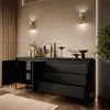 A modern living room with a black dresser and decorative items. Produktbild-Vorschau