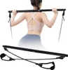 Schwarzes Pilates-Bar-Set mit Widerstandsbändern, gezeigt in Benutzung von einer Frau von hinten und separat ausgelegt Productafbeelding-voorbeeld