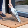 A person is using a handheld vacuum cleaner on a doormat near a doorway. Anteprima dell’immagine prodotto