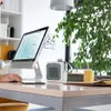 A person's hand is using a computer mouse on a desk with a small heater and a plant in the background. Voir les images du produit