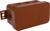 A brown electrical junction box with multiple entry points and mounting bracket. Podgląd zdjęcia produktu