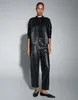 A woman modeling a black leather jacket and pants set against a light gray background. Produktbild-Vorschau