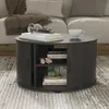 A round coffee table with storage is placed in a living room setting, next to a sofa. Náhled obrázku produktu