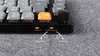A close-up view of a mechanical keyboard, showing the bottom edge with indicator lights and switches, and a portion of the keys. Produktbild-Vorschau