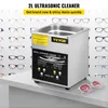A VEVOR 2L ultrasonic cleaner is shown on a shelf, with a background of various eyeglasses. A pair of sunglasses is placed in front of the cleaner. Náhľad obrázku produktu