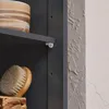 A close-up view of a dark gray cabinet shelf with a brush and a decorative pot. Náhľad obrázku produktu