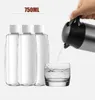 A hand is pouring water from a silver and black electric kettle into a clear glass. Three clear bottles with white caps are lined up on the left side of the image. Náhled obrázku produktu