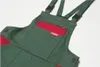A close-up view of a green and red child's overall. Náhľad obrázku produktu