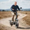 An older man rides an electric scooter on a dirt road in a rural area. Náhled obrázku produktu
