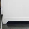 A close-up view of the bottom section of a white cabinet, showing its base and the floor it rests on. Produktbild-Vorschau