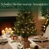 A decorated table setting with a small Christmas tree, candles, and wine glasses. Anteprima dell’immagine prodotto