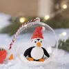 A Christmas ornament with a penguin inside, surrounded by artificial snow and greenery. Produktbild-Vorschau