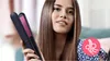 A woman is holding a hair straightener and smiling. Voir les images du produit