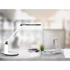 A modern desk lamp is shown on a white desk next to a computer monitor and a small potted plant. Produktbild-Vorschau