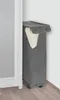 A gray laundry hamper with a white towel inside, placed in a corner next to a white cabinet. Náhled obrázku produktu