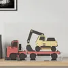 A toy truck carrying a toy excavator inside a transparent display box. Voir les images du produit