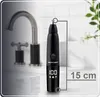A black nose and ear trimmer is shown on a countertop next to a faucet. Náhled obrázku produktu