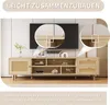 A wooden TV stand with rattan details in a living room setting, with a television mounted on the wall above it. Produktbild-Vorschau