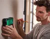 A man is using a laser measuring device on a wall and marking a spot with a pencil. Produktbild-Vorschau