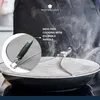 A close-up of a splatter screen on a frying pan with steam rising. Produktbild-Vorschau
