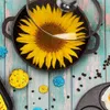 A top-down view of a cooking pot with a sunflower inside, surrounded by decorative elements and coffee beans. Produktbild-Vorschau