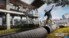 A skateboarder performing a trick on a pipe in front of a modern building. Produktbild-Vorschau