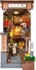 A miniature diorama of a Japanese alleyway with shops and cherry blossoms. Voir les images du produit