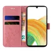 A pink flip phone case with floral and butterfly designs, showing card slots and a banknote, next to a smartphone displaying a colorful abstract image. Produktbild-Vorschau