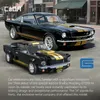 A black and gold Shelby Mustang GT350-H model car and a Lego-style replica of the same car are displayed on a street background. Anteprima dell’immagine prodotto