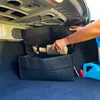 A person is placing a bottle into a car trunk organizer. Náhled obrázku produktu