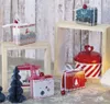 Christmas-themed gift boxes and decorations arranged on wooden shelves. Produktbild-Vorschau