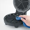 A hand is cleaning a heart-shaped waffle maker with a blue cloth. Anteprima dell’immagine prodotto