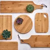 A collection of bamboo cutting boards with succulents on them, arranged on a textured light gray surface. Anteprima dell’immagine prodotto
