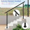 A black stainless steel handrail installed on outdoor stairs with a wooden fence and greenery in the background. Produktbild-Vorschau