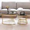 Two round coffee tables with black marble-look tops and gold metal bases are placed on a light-colored rug in front of a sofa. Náhľad obrázku produktu