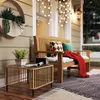 A cozy porch scene with a wooden bench, a small table, and decorative pillows and a blanket. Anteprima dell’immagine prodotto
