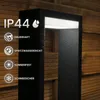A black outdoor lamp with water droplets on it, set against a wooden fence. Anteprima dell’immagine prodotto