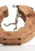 A decorative wooden sculpture with a metallic figure climbing on it, set against a white background. Náhled obrázku produktu