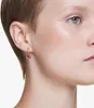 Close-up of a woman's ear wearing a heart-shaped earring. Produktbild-Vorschau