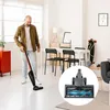 A man is vacuuming a living room with a handheld vacuum cleaner. A close-up of the vacuum cleaner head is shown in a circle. Produktbild-Vorschau